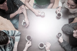 Creative Setting: Students sitting around table drinking coffee in college cafe